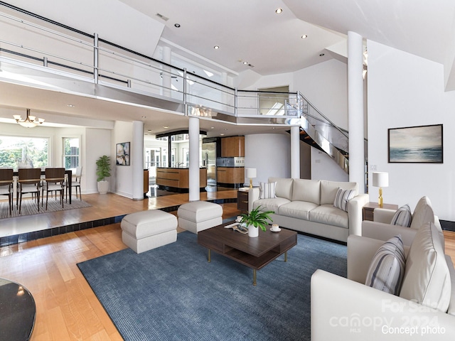 living room featuring hardwood / wood-style flooring, a high ceiling, and a notable chandelier