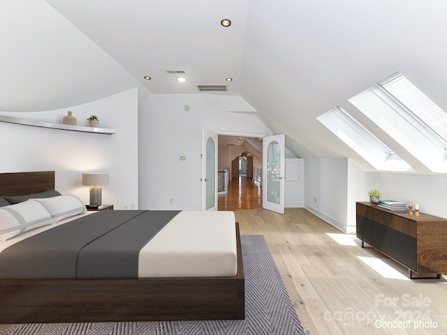 bedroom with light hardwood / wood-style floors and vaulted ceiling with skylight