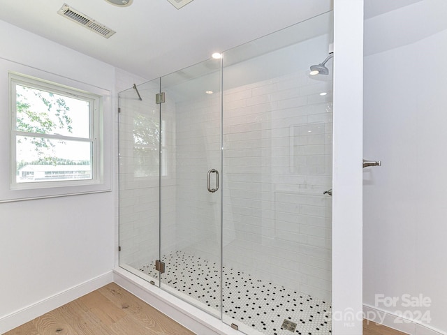 bathroom with wood-type flooring and walk in shower