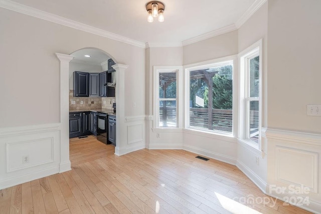 unfurnished dining area featuring light hardwood / wood-style floors, ornate columns, and ornamental molding