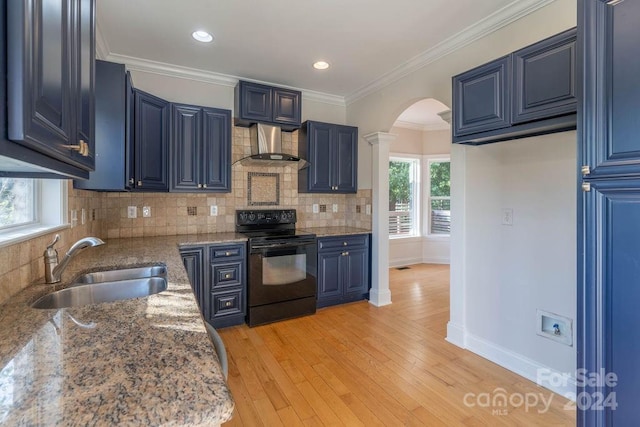 kitchen with wall chimney exhaust hood, black range with electric cooktop, blue cabinets, sink, and light hardwood / wood-style flooring