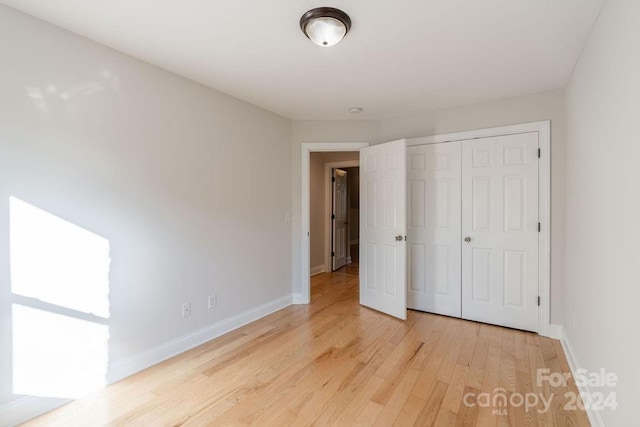 unfurnished bedroom with a closet and light hardwood / wood-style flooring