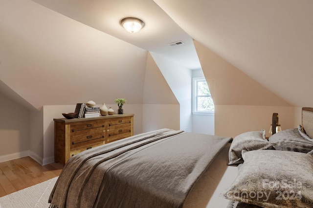 bedroom with hardwood / wood-style floors and vaulted ceiling