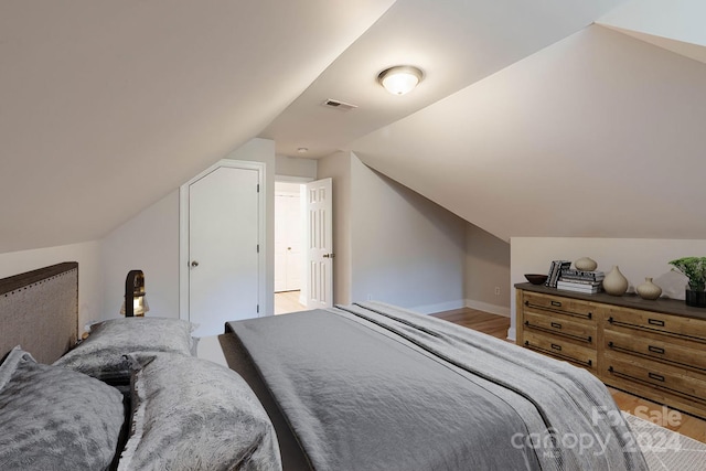 bedroom with light hardwood / wood-style flooring and vaulted ceiling