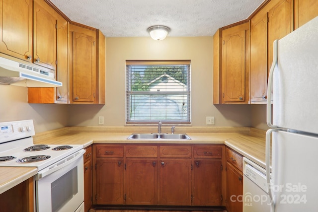 kitchen with white appliances, sink, and a textured ceiling