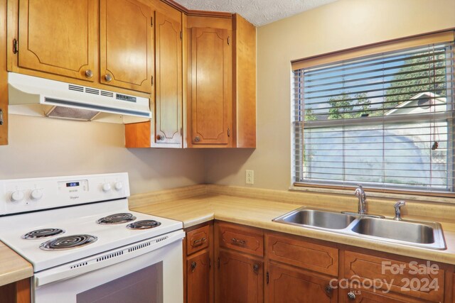 kitchen with sink, white range with electric stovetop, and a textured ceiling