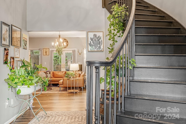 stairs featuring an inviting chandelier and hardwood / wood-style flooring