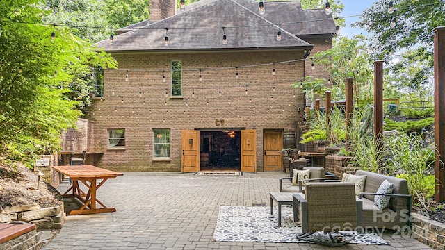 rear view of house with outdoor lounge area and a patio