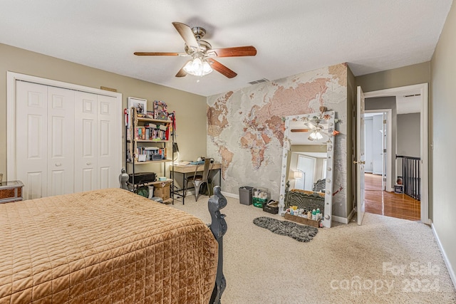 bedroom with a textured ceiling, ceiling fan, a closet, and carpet floors