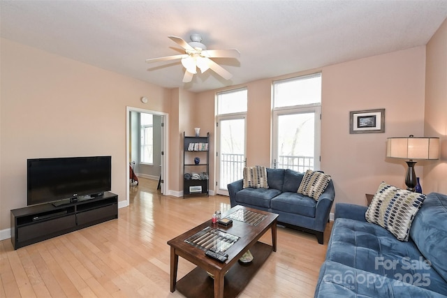 living room featuring ceiling fan and light hardwood / wood-style flooring