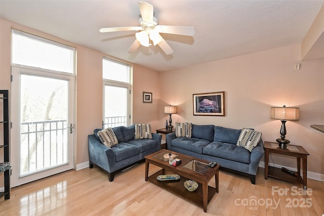 living room with light hardwood / wood-style flooring and ceiling fan