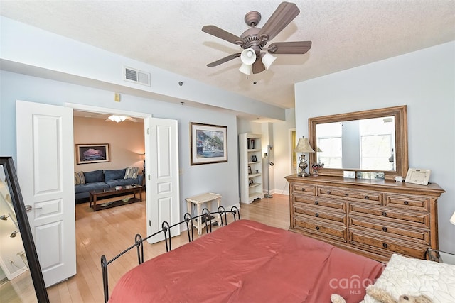 bedroom featuring a textured ceiling, light hardwood / wood-style flooring, and ceiling fan