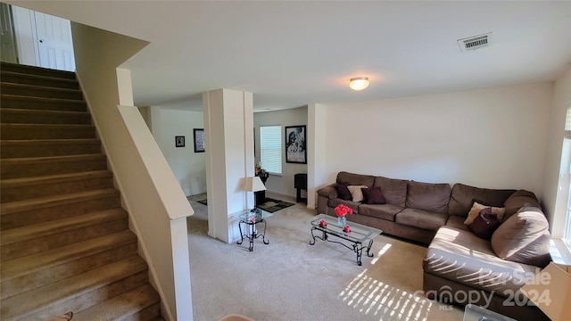 carpeted living area featuring stairs and visible vents