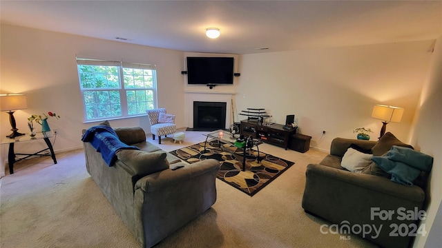 living room featuring a fireplace with flush hearth, carpet, visible vents, and baseboards