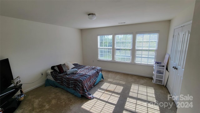 bedroom featuring carpet floors, a closet, visible vents, and baseboards