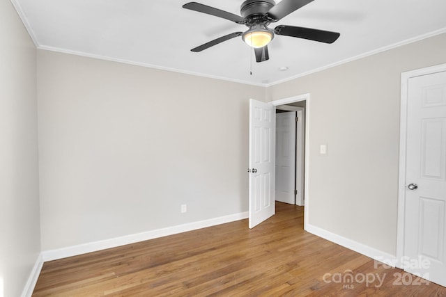 unfurnished bedroom with ceiling fan, ornamental molding, and hardwood / wood-style flooring