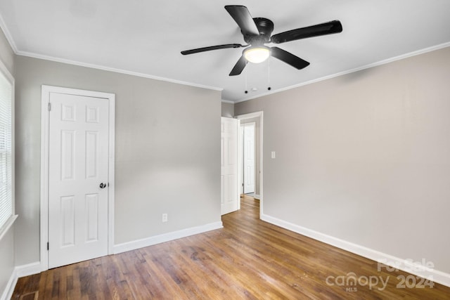 unfurnished bedroom with ceiling fan, hardwood / wood-style floors, and ornamental molding