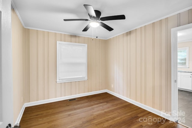 empty room featuring ceiling fan, ornamental molding, and hardwood / wood-style floors