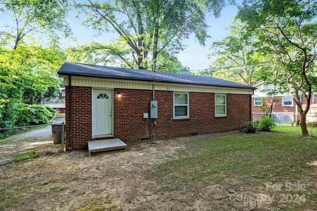 rear view of property featuring a lawn