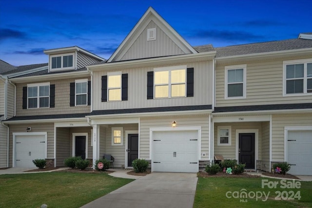 townhome / multi-family property featuring a lawn and a garage