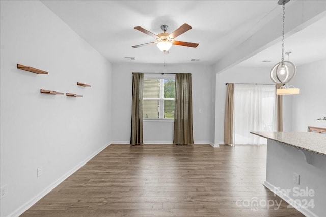 unfurnished living room with ceiling fan and dark hardwood / wood-style flooring