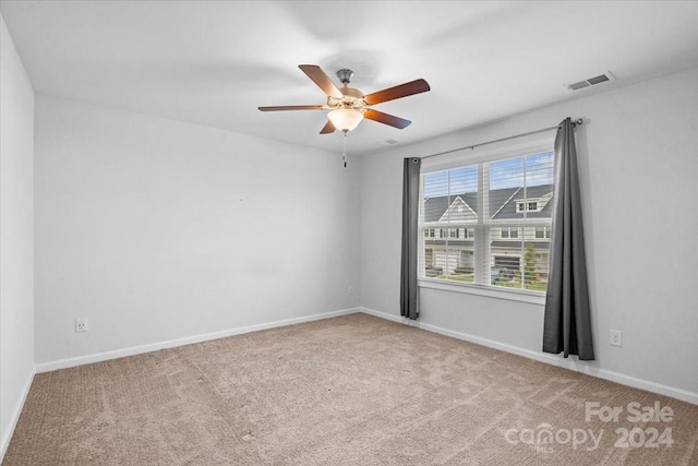 carpeted spare room featuring ceiling fan