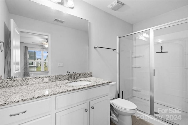 bathroom featuring toilet, a shower with door, ceiling fan, tile patterned floors, and vanity