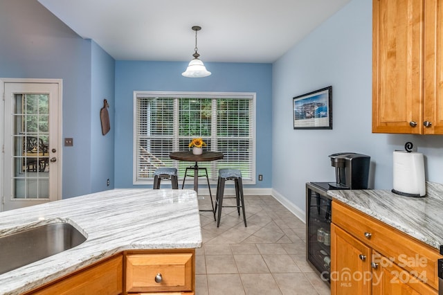 kitchen featuring decorative light fixtures, light tile patterned floors, and light stone counters