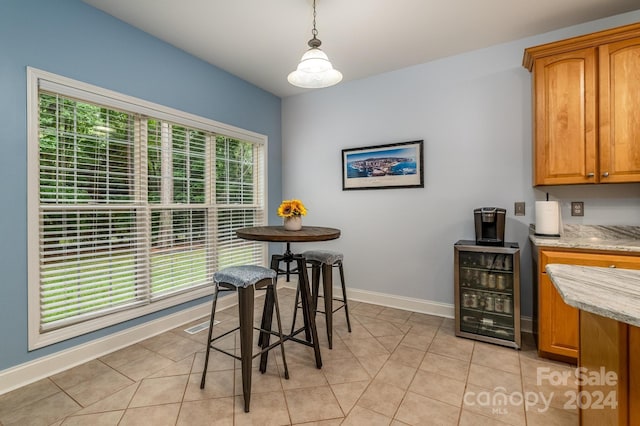 dining room with a wealth of natural light, light tile patterned flooring, and beverage cooler