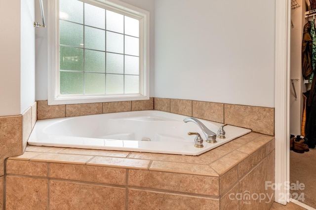 bathroom with a relaxing tiled tub