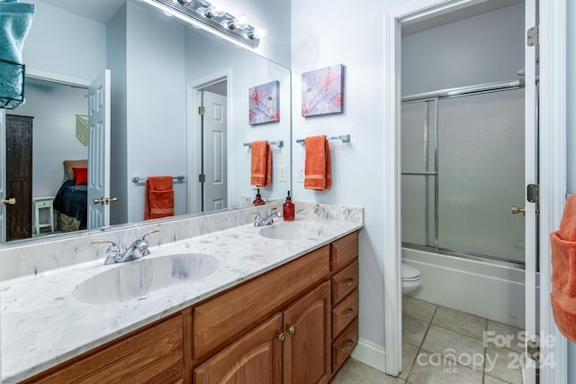 full bathroom with toilet, tile patterned floors, shower / bath combination with glass door, and vanity