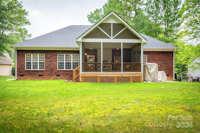 rear view of property featuring a sunroom and a lawn