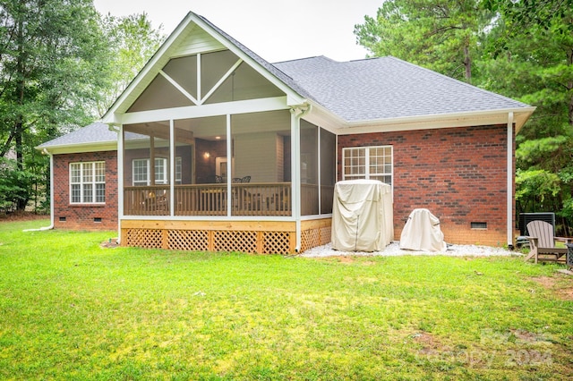 rear view of property featuring a sunroom and a yard