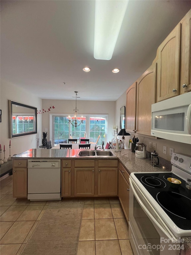 kitchen featuring white appliances, light brown cabinetry, kitchen peninsula, and sink