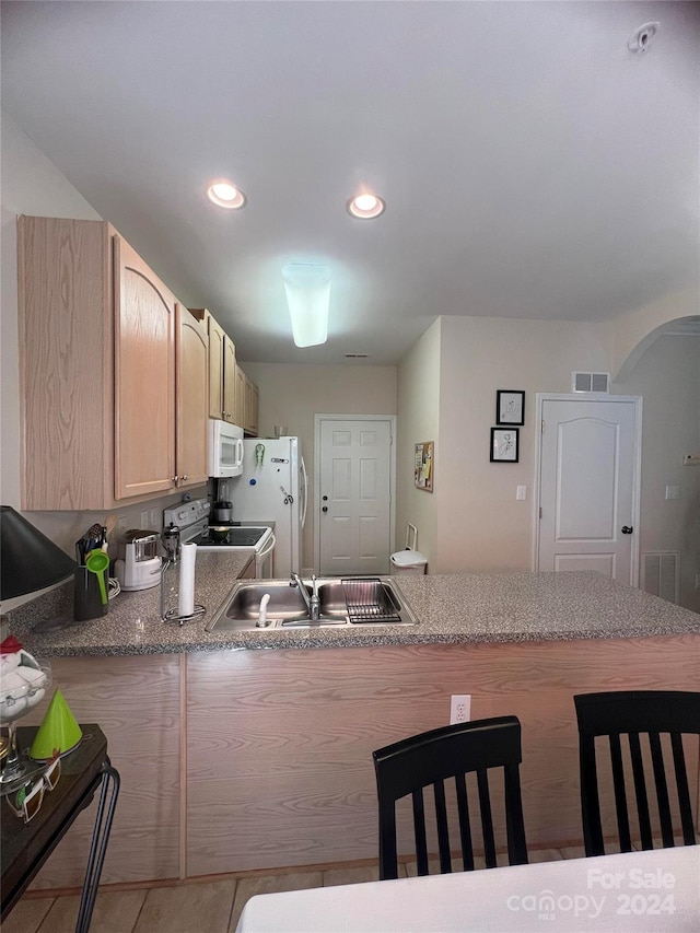 kitchen featuring white appliances, sink, and light brown cabinets