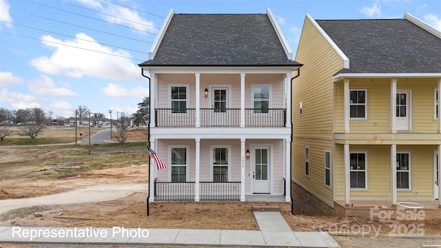 view of front of property with a porch, a balcony, and a shingled roof