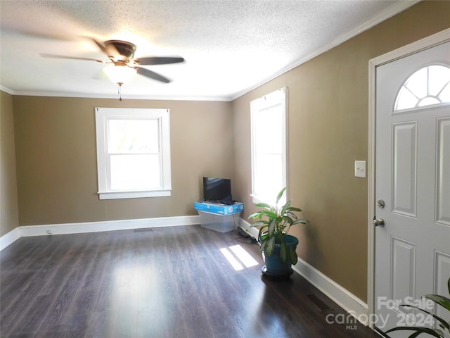 foyer featuring ceiling fan, a textured ceiling, dark hardwood / wood-style floors, and crown molding