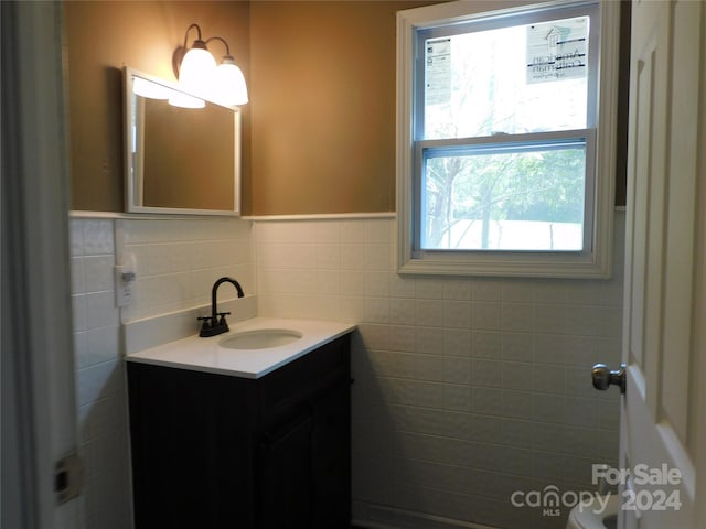 bathroom featuring plenty of natural light, tile walls, and vanity