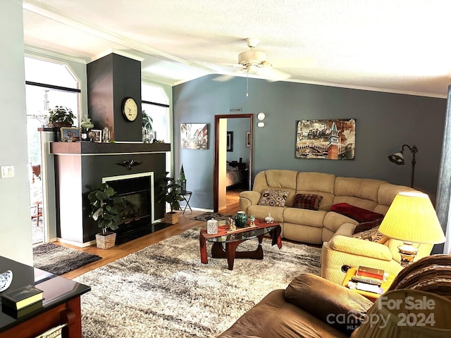 living room featuring lofted ceiling, wood-type flooring, crown molding, and a textured ceiling