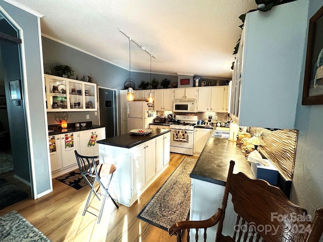 kitchen featuring light hardwood / wood-style floors, pendant lighting, a center island, white appliances, and white cabinetry