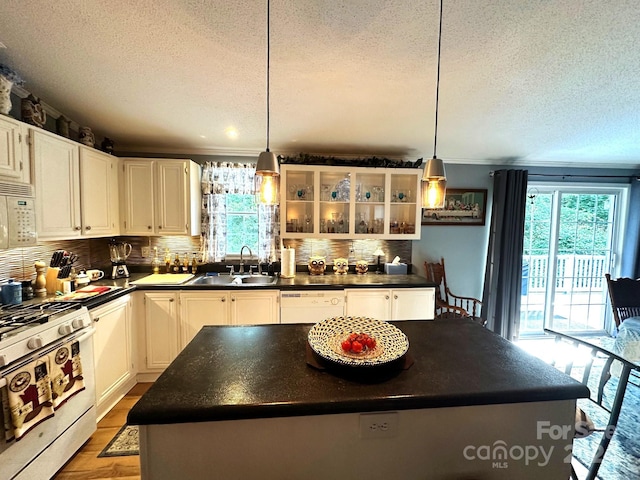 kitchen featuring white appliances, white cabinetry, and a center island