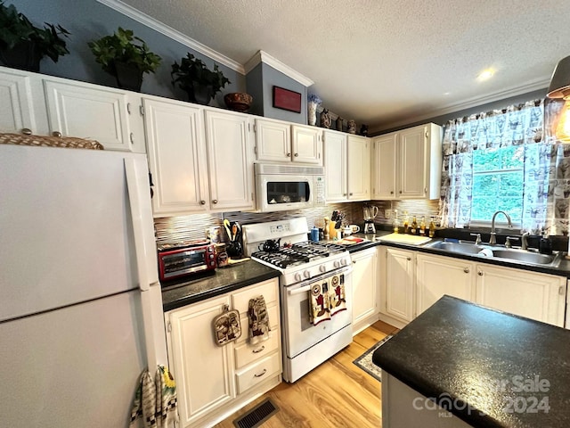 kitchen with white cabinetry, sink, light hardwood / wood-style floors, and white appliances