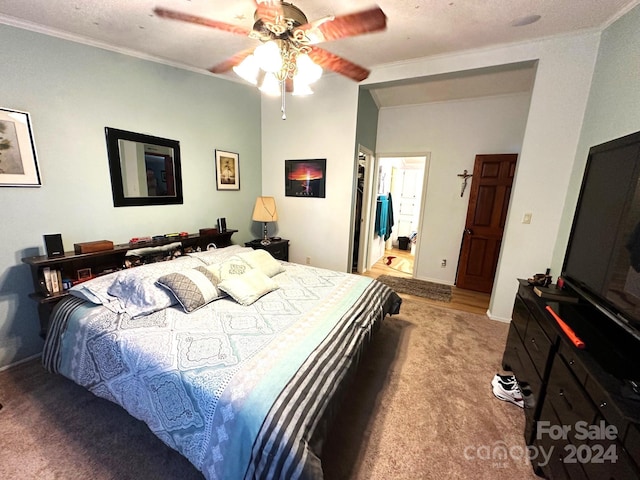 bedroom with ceiling fan, ensuite bath, ornamental molding, and a textured ceiling