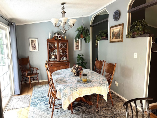 dining area featuring hardwood / wood-style floors, crown molding, and a chandelier