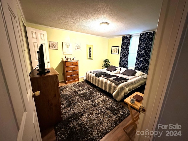 bedroom with wood-type flooring and a textured ceiling