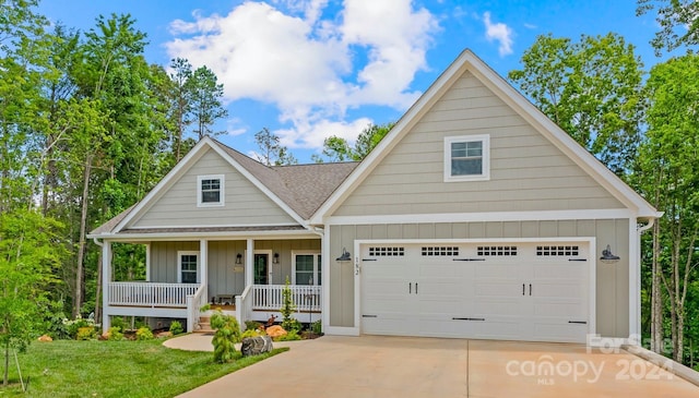 view of front of property featuring covered porch, a garage, and a front yard