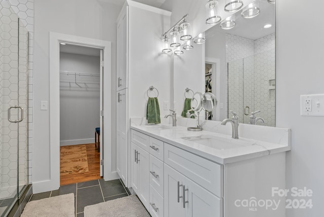 bathroom with tile patterned flooring, vanity, and a shower with shower door