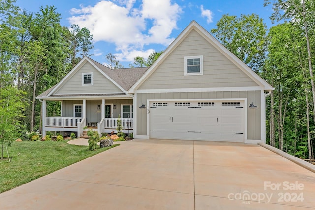 view of front facade featuring covered porch, a garage, and a front lawn