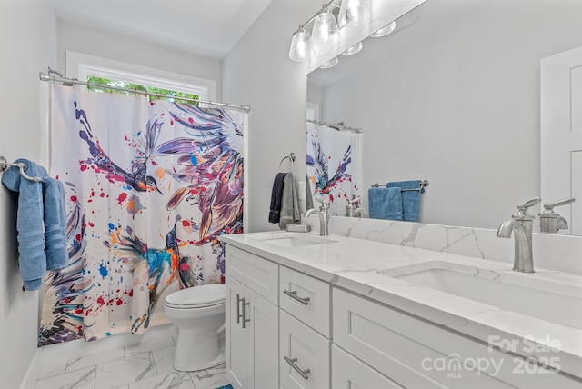 full bathroom featuring toilet, double vanity, marble finish floor, and a sink
