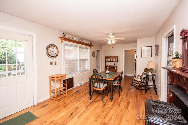 dining area with light wood-type flooring and ceiling fan